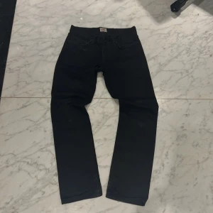 Vintage Svarta Edwins - Snygga svarta jeans ED-77 från Edwin med klassisk femficksdesign och dragkedja. Perfekta för en stilren look. Märkeslogga på bakfickan ger en extra touch. japanskt denim knappt fejdat förutom lite heel drag. Pris lätt diskuterbart vid snabb affär 