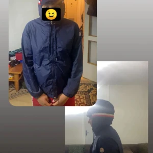 Mörkblå vindjacka från Moncler - Säljer en snygg mörkblå vindjacka från Moncler med huva och dragkedja. Jackan har en randig detalj i rött och vitt på huvan och Moncler-logga på ärmen. Perfekt för blåsiga dagar!