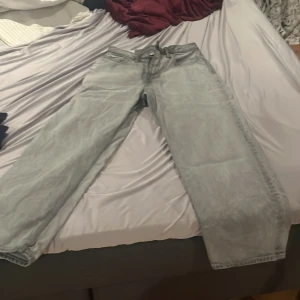 Grå loose fit jeans från H&M - Säljer ett par grå loose fit jeans från H&M. De har en klassisk femficksdesign och stängs med dragkedja och knapp. Perfekta för en avslappnad stil. Tillverkade i Bangladesh.