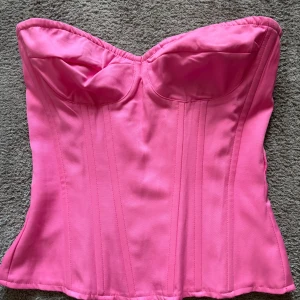 rosa korsett - En söt rosa korsett från prettylittlething i storlek 32/Xxs. På insidan finns det ”gummi” som gör att den sitter på plats💕