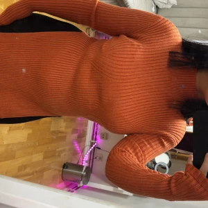 Orange ribbad polo tröja  - Säljer en snygg orange ribbad tröja med långärmad design. Tröjan har en tight passform som framhäver figuren och är perfekt för höst och vinter. Använt en gång , NAKD.