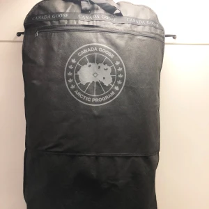 Svart Macculloch Parka från Canada Goose - Säljer en stilren svart Macculloch Parka från Canada Goose. Jackan har en klassisk design med knappar och dragkedja framtill samt det ikoniska Canada Goose-märket på bröstet. Perfekt för kalla dagar med sin robusta och varma konstruktion. Nypris 20 000kr kvitto medföljer