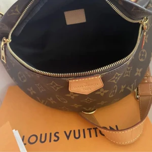 Brun axelväska från Louis Vuitton - Säljer en snygg brun axelväska från Louis Vuitton med det klassiska monogrammönstret. Väskan har en justerbar axelrem och en dragkedja för säker förvaring. Perfekt för att bära dina nödvändigheter med stil.