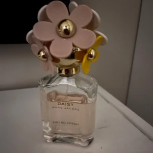 Daisy Eau So Fresh från Marc Jacobs - Säljer en flaska Daisy Eau So Fresh från Marc Jacobs. Parfymen kommer i en elegant glasflaska med en unik kork dekorerad med blommor i rosa och gult. Perfekt för den som älskar en fräsch och blommig doft. 75 ml men den är använd som du ser på bilden men mer än halva kvar . 
