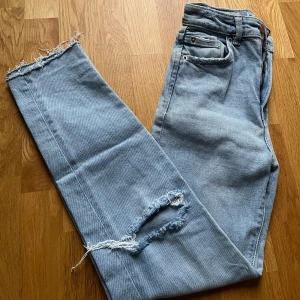 Blå jeans med slitningar Stradivarius - slim fit  - Slitna detaljer lite överallt, benslut, på fickorna, längst upp på midjan, knäna. enda defekten skulle vara att slitningarna här och var men mest knäna drar mot sidorna efter tvätt, men ej använda mycket! Även knappen har ändrat färg lite (se bild) 