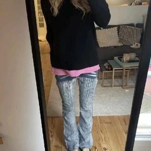 Randiga jeansbyxor - Säljer ett par coola randiga jeansbyxor i blått och vitt. De har en unik design med slitna detaljer framtill och en bootcut-stil som ger en retro vibe. Perfekta för både vardag och fest! 🕺
