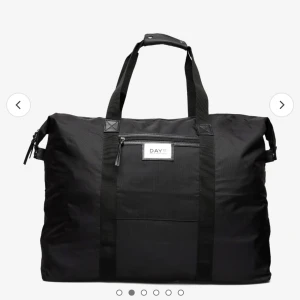 Svart weekendväska från DAY ET - Snygg och rymlig svart weekendväska från DAY ET. Perfekt för kortare resor eller som gymväska. Tillverkad i slitstarkt syntetmaterial med praktisk dragkedja och bekväma handtag. Stilren design som passar alla tillfällen.