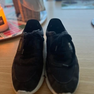 Svarta sneakers från Axel Arigato - Säljer ett par svarta sneakers från Axel Arigato i bra skick. De har en stilren design med vita sulor och svarta snören. Perfekta för både vardag och fest. Skostorlek herr 43. Pris går att diskutera 