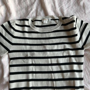 Randig tröja från Gina Tricot - Säljer en snygg randig tröja från Gina Tricot i svart och beige. Den har korta ärmar och är perfekt för både vår och sommar. Tröjan är i bra skick och passar perfekt till jeans eller kjol. Perfekt för en alla! ❤️❤️