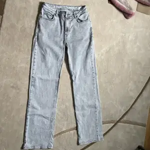 Säljer ett par snygga grå jeans i wide fit. De är i bra skick och har en klassisk femficksdesign med knapp och dragkedja framtill. Perfekta för en avslappnad stil och passar till alla säsonger. Sköna och stilrena, dessa jeans är ett måste i garderoben!