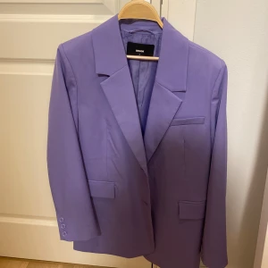 Lila kavaj och byxor från BikBok - Säljer en snygg lila kavaj och matchande byxor från BikBok. Setet är oversized, dvs kavajen och byxorna sitter lite längre. Kavajen är i storlek S och byxorna i storlek 38. Använd 1 gång. 