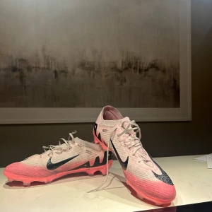 Nike vapor 15 mad brilliance storlek 45 - Hej! Säljer ett par vapor 15 mad brilliance då jag använt de ett tag (2 månader ca) och tycker att de är dags för ett par nya skor, riktigt sköna men bäst av allt så är de riktigt snygga, ända defekten är att de behöver renas annars är de inget dåligt med skorna, kontakta vid frågor!