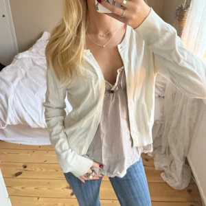 Stickad vit kofta  - Säljer en superfin vit kofta. Den har en klassisk design med knappar framtill och långa ärmar. Perfekt för vår och sommar, och funkar både till vardags och fest. Koftan är i bra skick och passar perfekt över en topp eller klänning. 🕊️