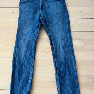 Blå jeans från Lee, “west” 30/32 - Säljer ett par klassiska blå jeans från Lee i storlek W30 L32. De har en dragkedja och knapp framtill, och är i mycket bra skick. Perfekta för både vardag och fest! 👖Loose Fit
