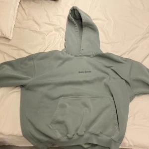 Grön hoodie från District Forty Six - Säljer en grön hoodie från District Forty Six i storlek L. Den har en cool design med en stor grafisk bild på baksidan och en liten logga på framsidan. Perfekt för höst och vinter med sin mysiga och varma känsla. Passar både till vardags och chillkvällar. 🧥