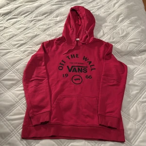 Cerise hoodie från Vans - Säljer en snygg cerise hoodie från Vans i storlek S. Den har en klassisk design med 'Off The Wall' tryck på framsidan och en stor ficka. Perfekt för höst och vinter, och den är i mycket bra skick. Grym för både chill och skate!