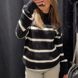 Randig stickad tröja - Säljer denna mysiga stickade tröjan från lager.  Passar bra inför kyliga dagar med sin varma och bekväma passform. Tröjan har använts fåtal gånger men är i gott och fint skick! Den är både stilren och enkel att matcha med olika outfits. Perfekt för höst och vinter!