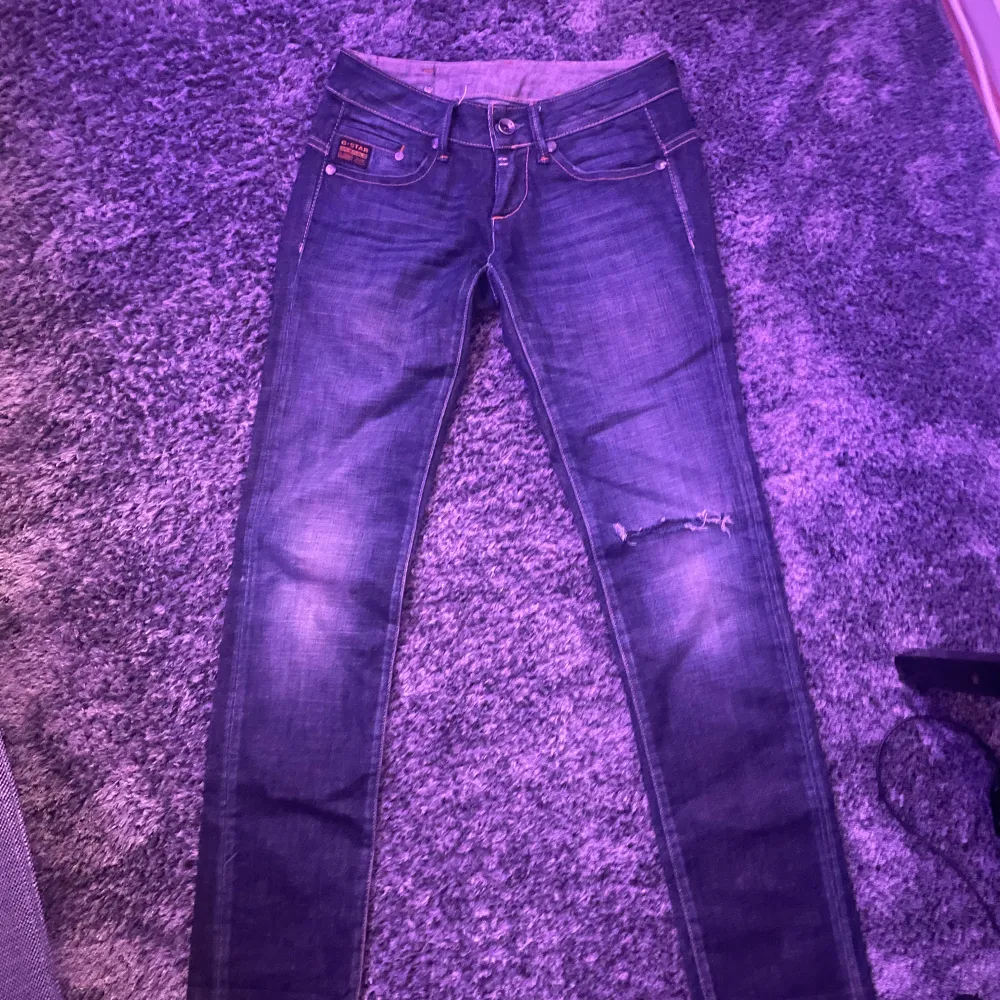 Säljer ett par snygga mörkblå jeans från G-Star i bra skick. De har en cool slitning på benet. Passar till det mesta och är superbekväma! Jättebra skick och midjan går att tajta till på baksidan!😄skriv gärna om du har frågor💞. Jeans & Byxor.