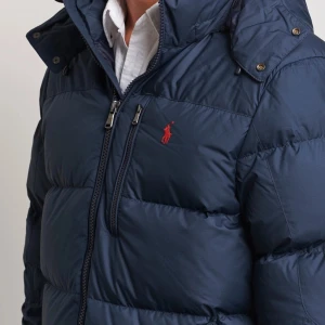Mörkblå Ralph Lauren Vinterjacka (M) - Säljer en snygg mörkblå dunjacka från Polo Ralph Lauren i storlek M. Köpt under Januari iår och är i toppskick, säljes då jag vill ha en glansig svart istället. Nypris 5500