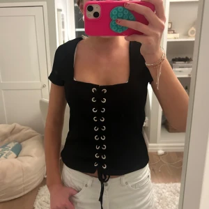 Svart topp med snörning - Säljer denna efterfrågade tröjan med snörning!! Passa på