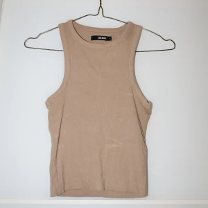 Beige ribbad linnetopp från Bik Bok - Säljer en snygg beige ribbad linnetopp från Bik Bok i storlek S. Perfekt för sommardagar eller som ett basplagg i garderoben. Toppen är ärmlös och har en stilren design som passar till det mesta. Skicka ett meddelande vid intresse!