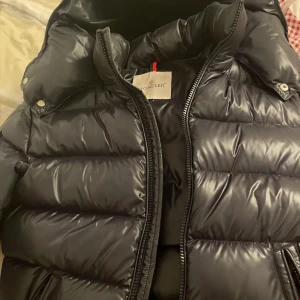 Moncler Maya jacka - Snygg dunjacka från Moncler, modell Maya i mycket bra skick. Köptes av en annan tjej förra vintern. Nfc skannern på sidan av armen funkar inte då det är en äldre modell som köptes för länge sedan men nfc skann och qr finns inuti även bevis bild (4)