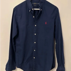 Mörkblå skjorta från Ralph Lauren - Säljer en stilren skjorta från Ralph lauren i slim fit, skjortan är i 8/10. Dm för ytterligare info