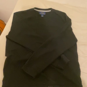  Polo Ralph Lauren tröja  - Säljer en stilren svart tröja från Polo Ralph Lauren i storlek L. Tröjan har en klassisk design med långärmade ärmar och märkeslogga diskret placerad. Perfekt för både vardag och festliga tillfällen. Passar bra till höst och vinter.