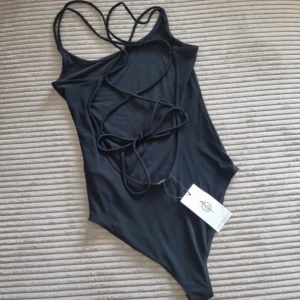 Svart body med knytning i ryggen - Jättefin, med prislappen kvar!🩷 (Den är svartare i verkligheten)