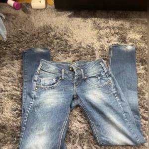 Blå jeans från Calypso Jeans - Säljer ett par snygga blå jeans från Calypso Jeans i storlek XS. De har en klassisk femficksdesign med slitna detaljer för en cool look. Perfekta för vardagsbruk!
