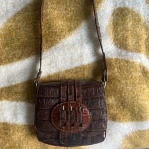 Vintage axelremsväska - Köpt vintage i Tyskland men har ej använt. Har tre fack och stängs med clip på framsidan. Kan mötas upp i Örebro eller skickas mot frakt.