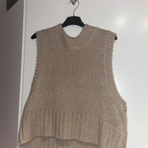 Beige stickad väst från VILA - Säljer en superfin beige stickad väst från VILA. Den är perfekt för lager-på-lager under hösten och vintern. Västen har en ribbad kant och är i ett mjukt och bekvämt material. Passar perfekt till vardagar. (Inte super mycket använd)