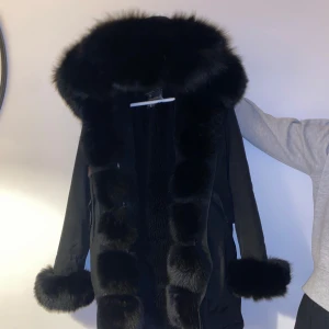 Svart parkajacka med pälsdetaljer - Säljer min svarta parkajacka med äkta päls!  Väldigt varm och gosig! Har användt under en vinter och har sedan hängt i garderob endast!  Öppen för byte och pris kan diskuteras! 