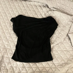 Svart offshoulder topp - Snygg svart  topp i mjukt material. Perfekt för en stilren look. Passar bra till både jeans och kjol.