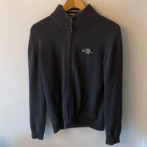 Tjocktröja Gant - Säljer en fin stickad tjocktröja med dragkedja från gant, på baksidan finns en amerikansk flagga, storleken är 170 cm men sitter som small, nypris runt 900kr, mitt pris är 349kr inga skador eller defekter, skriv gärna om ni har frågor eller funderingar!🤟😊