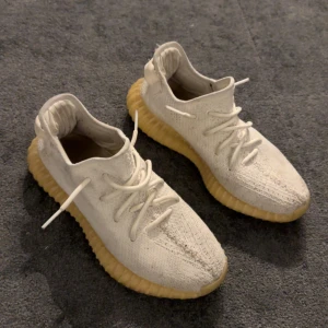  Adidas Yeezy sneakers - Säljer ett par Yeezy cream white. Skorna har en karakteristisk ribbad sula i gult och är perfekta för en trendig look. Kvitto och box ingår!