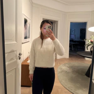 Vit fluffig tröja - Mysig vit tröja med fluffig textur. Den har en croppad design och långa ärmar, perfekt för kyligare dagar. Enkel och stilren, passar till många olika outfits.