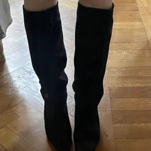 Svarta stövlar från H&M - Snygga svarta stövlar från hm som går till knäna. Strl 37 men stora i storleken så passar 38. Knappt använda. Låg klack ca 4-5 cm