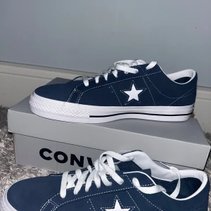  Converse one star pro blue - Snygga blå sneakers från Converse med vit sula och snörning. Skorna har en vit stjärna på sidan och är perfekta för en avslappnad stil. De kommer i en klassisk design med låg profil. Helt oanvända och tillkommer blå snören.