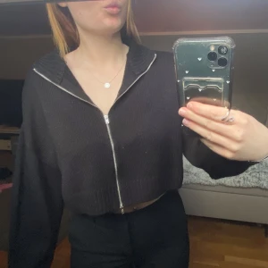 Svart croppad kofta med dragkedja - Snygg svart croppad kofta med dragkedja framtill som går att dra hela vägen så går även använda som en kofta