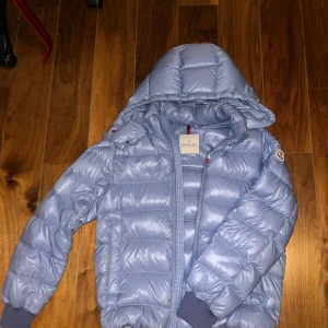 Ljusblå dunjacka från Moncler - Säljer en snygg ljusblå dunjacka från Moncler. Storlek 3. Dragkedjan tjärvar lite längst ner men går att använda.