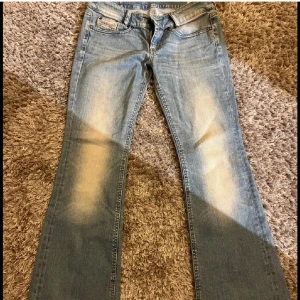 Blå jeans från Diesel - Snygga blå jeans från Diesel med en klassisk femficksdesign och diskret broderi på bakfickan. De har en lätt slitning på framsidan och en bekväm passform. Perfekta för en avslappnad stil. 37 cm tvärs över midja och ca 74 cm innerbensläng 