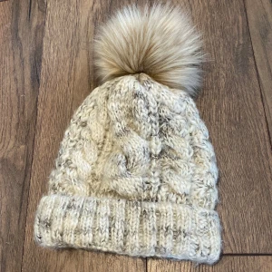 Fodrad Stickad Mössa - • Nyskick, använd fåtal gånger • Mössan är mycket stretchig och gjord för att passa på olika storlekar, minsta 44cm och största 64cm i omkrets • fodrad med fleece på insidan