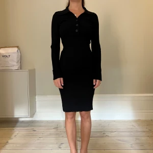 Svart klänning Gina Tricot - Svart ribbad klänning från Gina Tricot. Klänningen har knappar upptill och vid ärmslutet. Väldigt stretchig och mjuk.  Storlek S