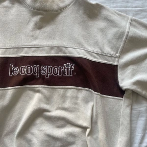 Le Coq Sportif - Baggy skitsnygg tjocktröja från LCS, typish 90tal! Har en liten krage som håller dig varm om nacken också :) XL och sitter exakt så!  Pris går att diskutera!