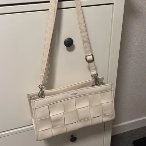 Väska - Liten handväska från Ulrika Sweden i en beige vit färg 