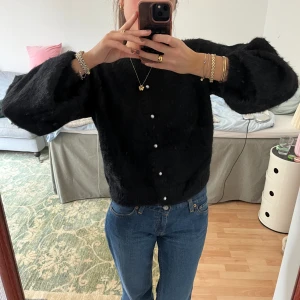 Ny kofta - Svart och fluffig. Ny med lappen kvar. Fin knappar!
