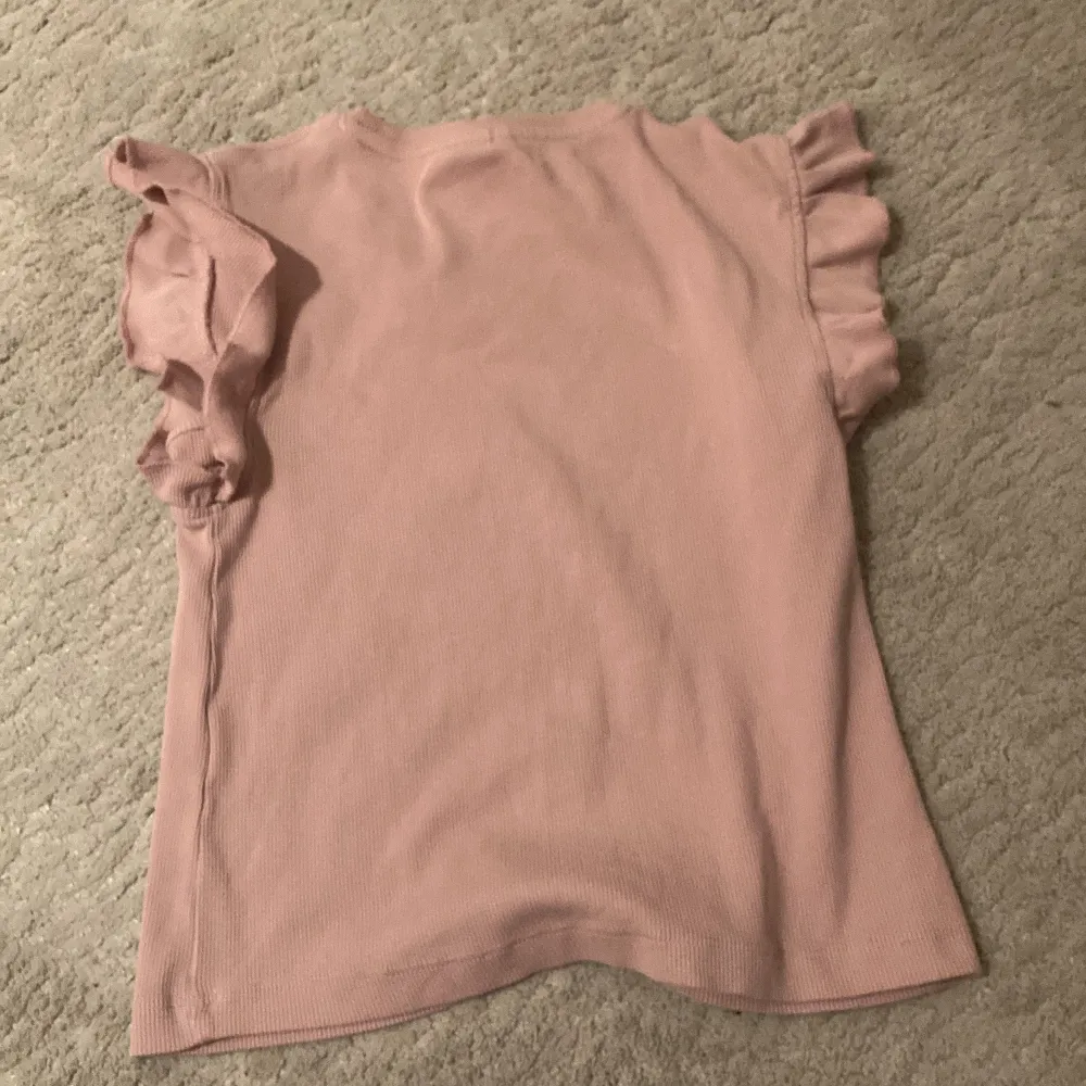 Säljer en superfin rosa topp från Zara i storlek 130. Toppen har söta volangdetaljer vid ärmarna och är gjord i ett mjukt och bekvämt material. . Toppar.