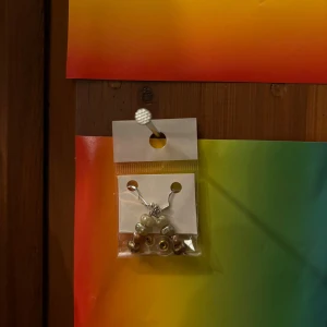 Söta örhängen med pärlor - Charmiga örhängen med pärlor i en fin design. Perfekta för att ge en elegant touch till din outfit. De är förpackade i en genomskinlig plastpåse med en enkel bakgrund.