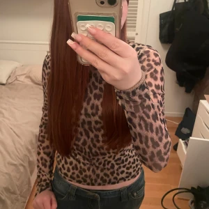 Leopardmönstrad topp från Gina Tricot - Säljer en snygg leopardmönstrad topp från Gina Tricot. Den har en tight passform och är långärmad, perfekt för att ge din outfit en trendig touch. Andvänd fåtal gånger. 💘